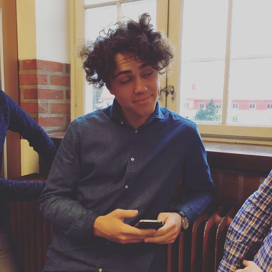 Tomas med vilt lockigt hår vid ett fönster